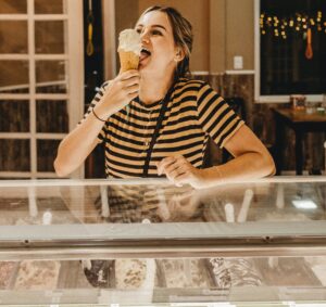 A tourist eating gelato in a shop in Florence